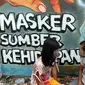 Anak-anak berbincang di depan mural bertema COVID-19 di kawasan Tanah Tinggi, Tangerang, Banten, Rabu (20/1/2020). Kegiatan ini dalam rangka mensosialisasikan bahaya penyebaran COVID-19 kepada warga pengguna jalan umum. (merdeka.com/Arie Basuki)