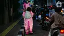 Warkuatno (41) bersama anak sulungnya, Bunga (9) berjalan kaki di pinggir Jalan Raya Fatmawati, Cilandak, Jakarta, Rabu (6/1/2021). Warkuatno harus memutar otak demi bisa bertahan hidup usai kehilangan pekerjaannya. (Liputan6.com/Faizal Fanani)