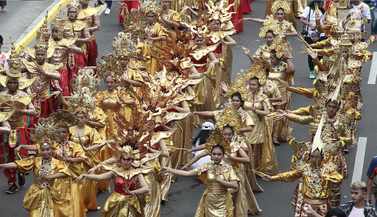 Peserta menggunakan pakaian tradisional turut meramaikan pawai obor Asian Para Games 2018 di Jakarta, Minggu (30/9). Nantinya api obor ini akan diarak di 17 titik lokasi di Ibu Kota. (Liputan6.com/Herman Zakahria)