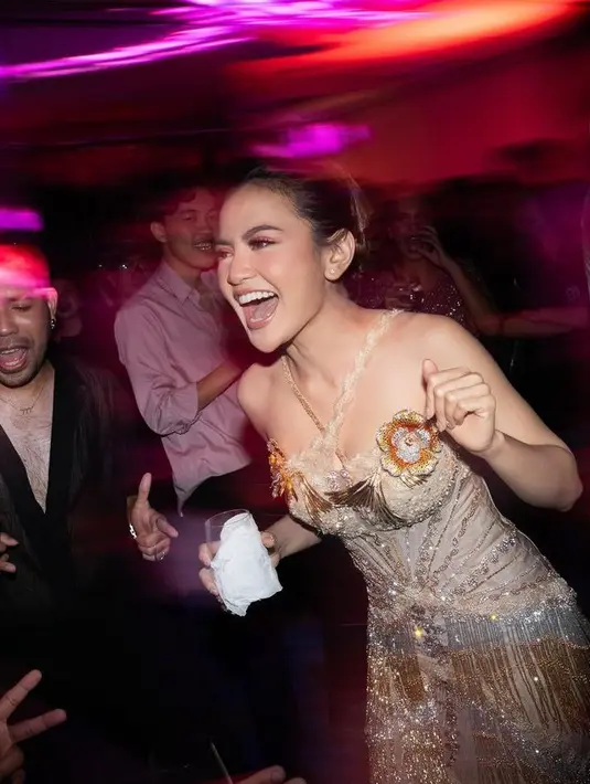 Gaun ini juga menampilkan pinggiran emas hingga perak ombré, yang terinspirasi oleh gadis glamor tahun 20-an. Rambutnya diikat cepol ke belakang dengan makeup bernuansa coklat [@axioo]