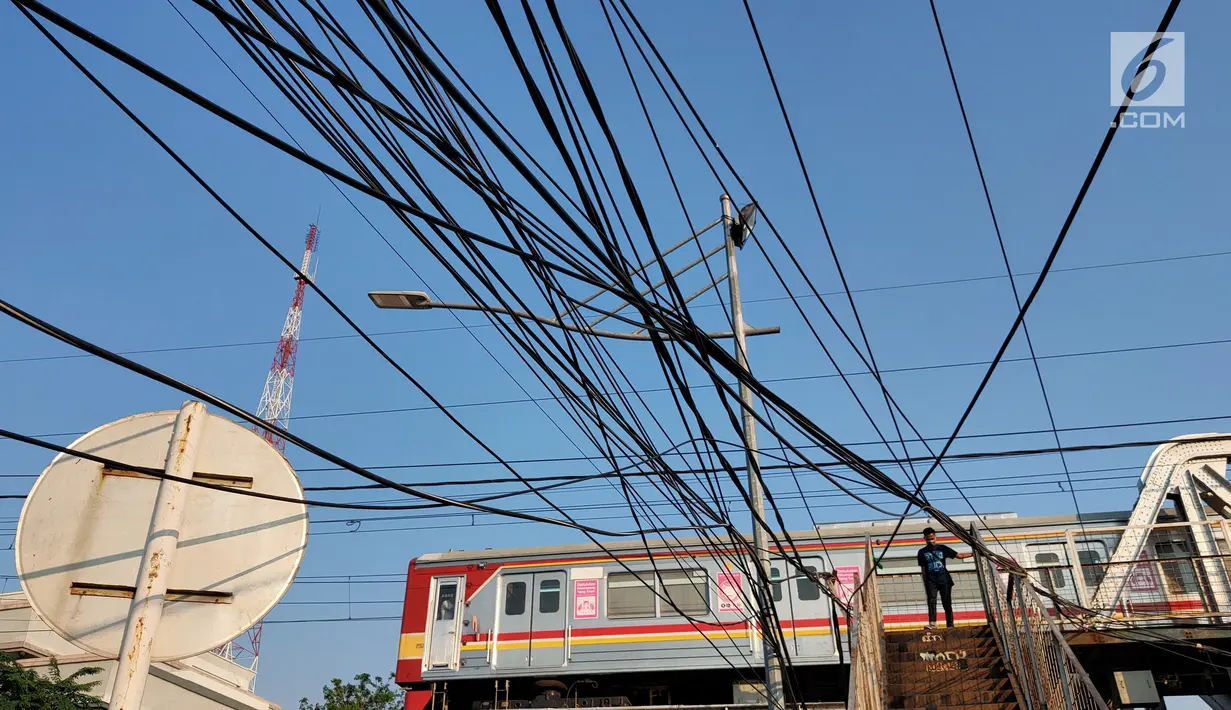 Instalasi kabel menjuntai yang berada di sekitar Jalan Gunung Sahari, Mangga Dua, Jakarta, Kamis (10/7/2019). Buruknya tata instalasi kabel di Ibu Kota menjadi penyebab banyaknya kabel semrawut, meskipun kondisi itu berbahaya serta mengganggu pemandangan. (Liputan6.com/Immanuel Antonius)