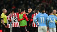 Manajer Manchester City, Pep Guardiola, berbincang dengan gelandang asal Inggris Sunderland, Luke O'Nien, saat pertandingan Liga Inggris antara Sunderland dan Manchester City di Stadion of Light, Sunderland, wilayah timur laut Inggris, pada 1 Januari 2026. (AFP/Andy Buchanan)