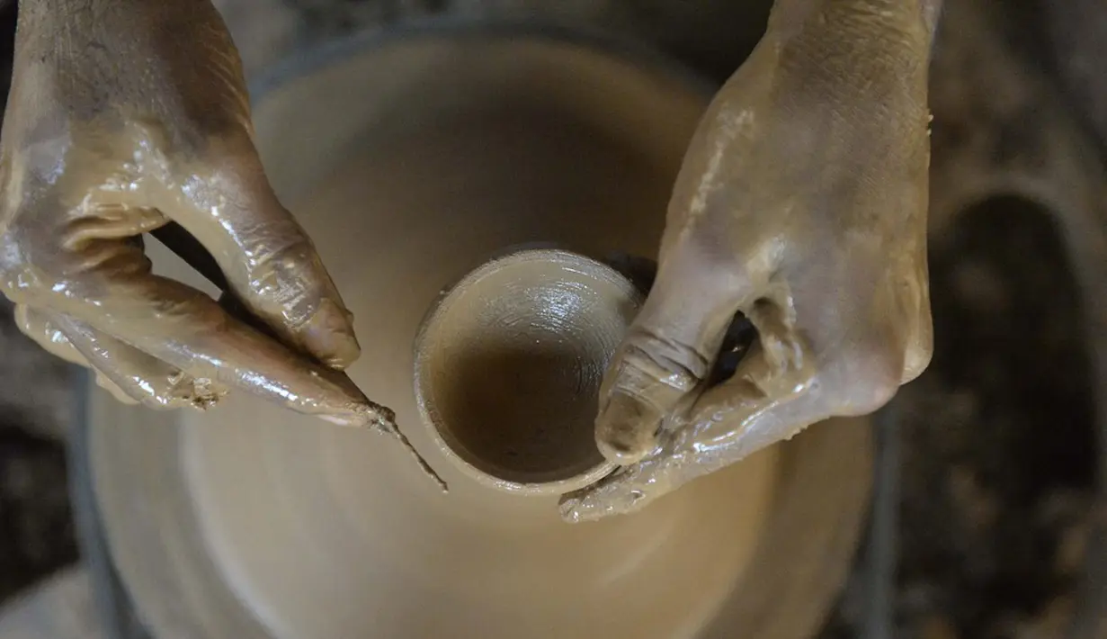 Seorang perajin tembikar membuat diyas atau pot minyak jelang Festival Diwali di pinggiran Hyderabad, India, 26 Oktober 2021. Diwali adalah salah satu festival besar yang dirayakan oleh umat Hindu, Jain, Sikh dan beberapa umat Buddha, terutama umat Buddha Newar. (NOAH SEELAM/AFP)