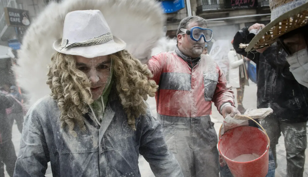Peserta saling melempar tepung saat mengikuti festival "Domingo Fareleiro" di desa Xinzo de Limia, Spanyol (21/1). Festival ini dikenal juga dengan nama Floury Sunday in Galician. (AFP/Miguel Riopa)