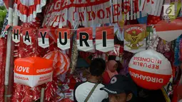 Pedagang bendera melayani pembeli di kawasan Pasar Jatinegara, Jakarta, Rabu (14/8/2019). Pedagang musiman memajang beragam jenis aksesoris seperti bendera merah putih, umbul-umbul dan lambang Garuda untuk perayaan HUT ke-74 RI pada 17 Agustus 2019 mendatang. (merdeka.com/imam buhori)