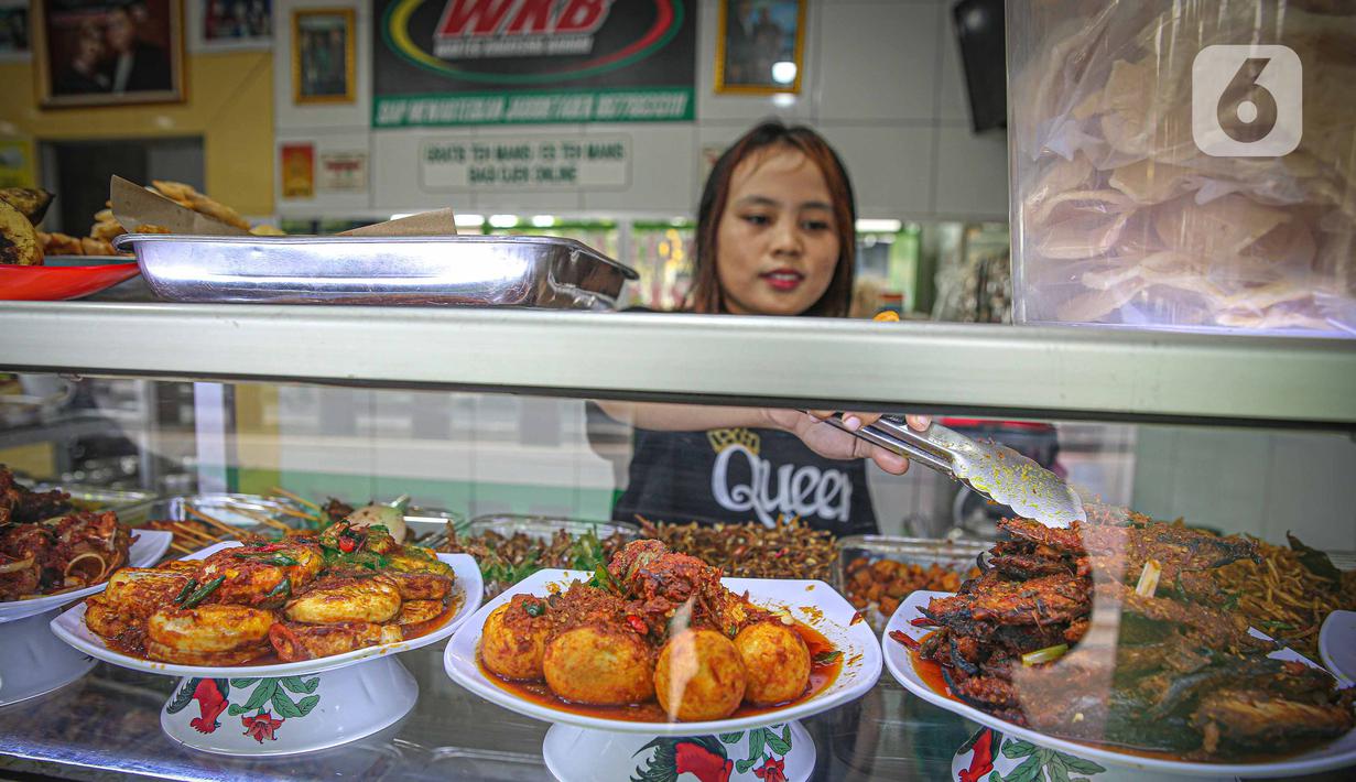 Pekerja melayani pengunjung di rumah makan Warteg Bahari, Jakarta, Rabu (1/12/2021). Dalam salinan Inmendagri tersebut juga tertulis waktu makan maksimal selama 60 menit. (Liputan6.com/Faizal Fanani)