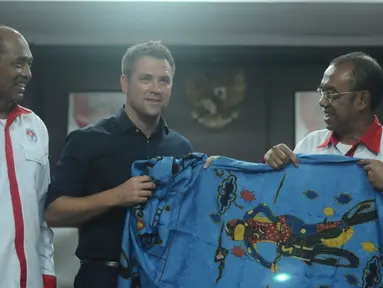 Mantan pemain tim nasional Inggris, Michael Owen (tengah) menerima suvenir batik dari Sesmenpora, Gatot S Dewa Broto (kanan) usai pertemuan di kantor Kemenpora, Jakarta, Senin (5/2). Pertemuan berlangsung terbuka. (Liputan6.com/Helmi Fithriansyah)