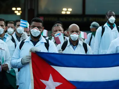 Petugas medis dan paramedis dari Kuba berpose setibanya di bandara Malpensa di Milan, Italia, Minggu (22/3/2020). Sebanyak 53 orang dokter dan perawat menjadi kontingen bantuan medis pertama Kuba untuk membantu mengendalikan pandemi virus Corona di kota kecil Crema, Lombardy. (AP/Antonio Calanni)