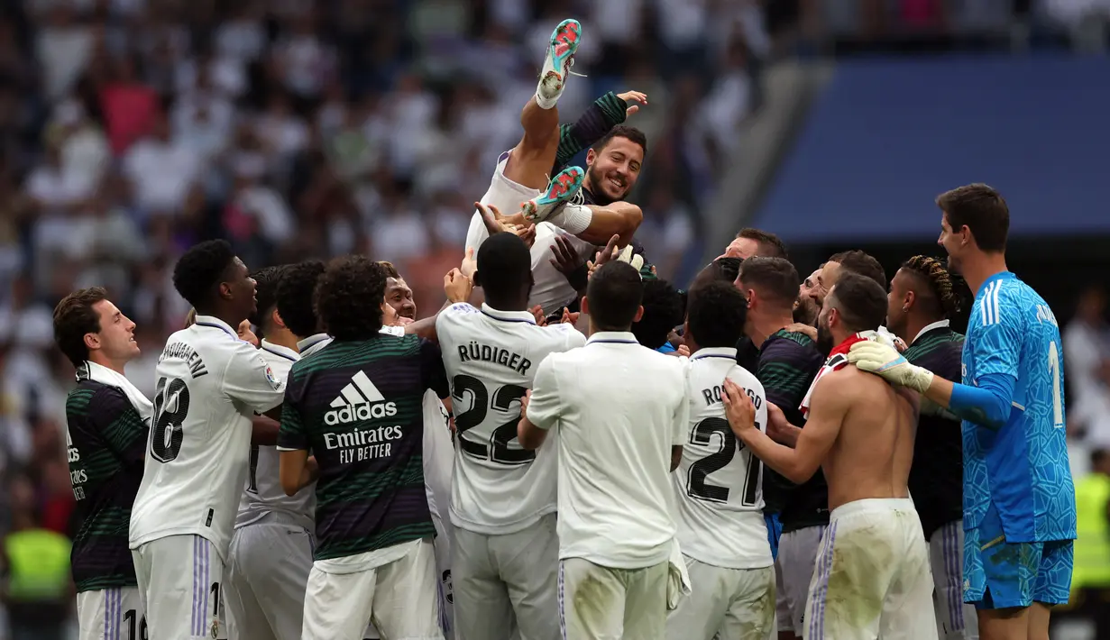 Sejumlah pemain Real Madrid melempar rekan satu timnya, Eden Hazard, ke udara sebagai bentuk perpisahan setelah menjalani pertandingan terakhirnya bersama Real Madrid di Santiago Bernabeu, Minggu (4/6/2023) malam WIB. (AFP/Pierre-Philippe Marcou)