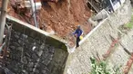Petugas melintas di dekat turap yang hancur di Jalan Damai, Ciganjur, Jakarta Selatan, Minggu (11/10/2020). Hujan yang deras sejak Sabtu (10/10/2020) sore mengakibatkan kawasan tersebut mengalami banjir sekaligus longsor. (Liputan6.com/Immanuel Antonius)