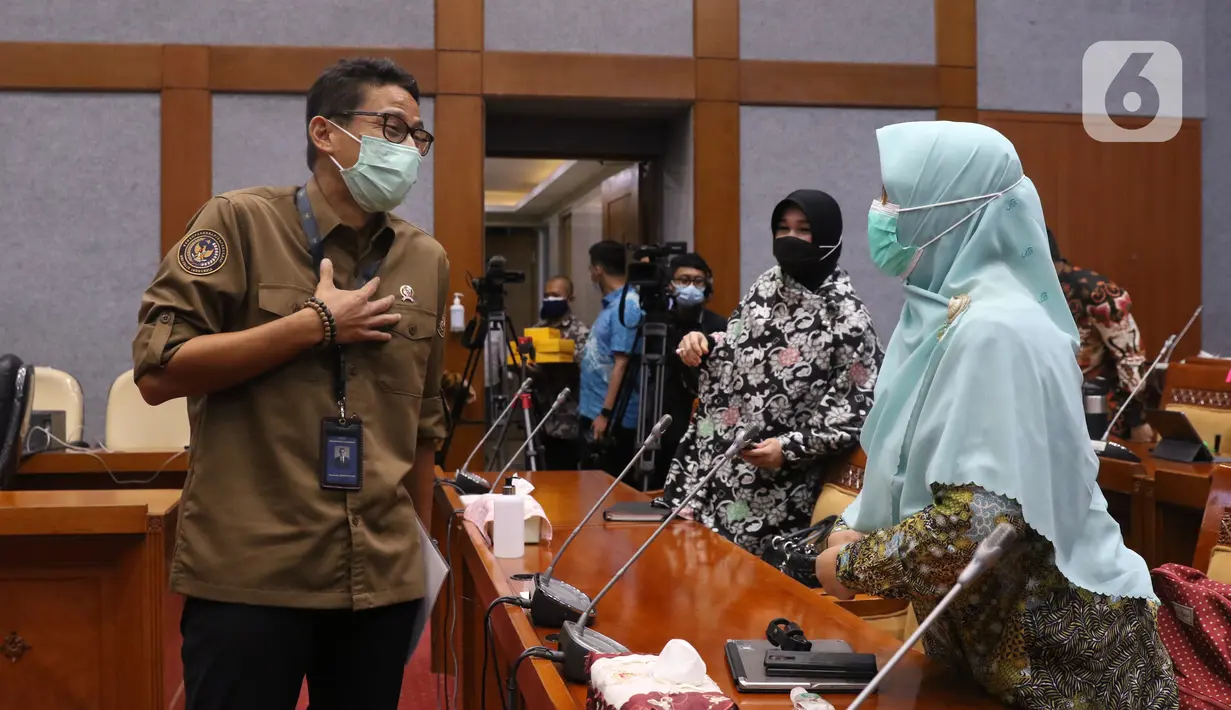 Menteri Pariwisata dan Ekonomi Kreatif Sandiaga Uno mengenakan masker saat Rapat Kerja dengan Komisi X di gedung DPR RI, Jakarta, Kamis (14/1/2021). Sandiaga Uno tampil dengan kemeja coklat dan celana hitam saat mengikuti rapat tersebut. (Liputan6.com/Angga Yuniar)