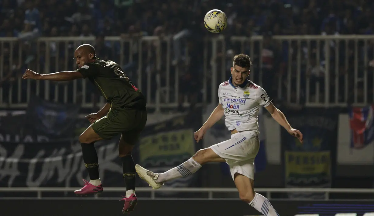 Bek Persib Bandung, Nick Kuipers, berebut bola dengan striker Tira Persikabo, Loris Arnaud, pada laga Shopee Liga 1 di Stadion Pakansari, Bogor, Sabtu (14/9). Tira Persikabo bermain imbang 1-1 atas Persib Bandung. (Bola.com/Yoppy Renato)