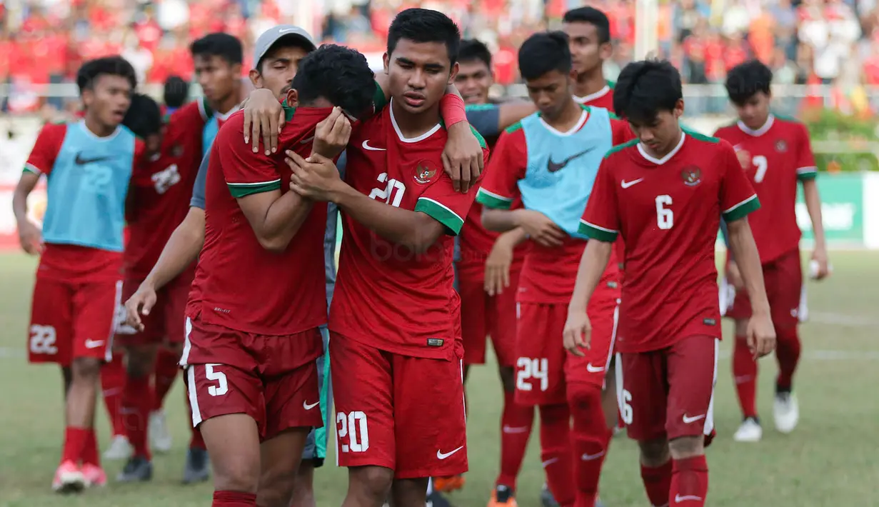 Bek Timnas indonesia U-19, Nurhidayat Haji Haris, ditenangkan Asnawi Mangkualam usai kalah dari Thailand U-19 pada laga Piala AFF U-18 di Stadion Thuwunna, Yangon, Jumat (15/9/2017). Indonesia kalah adu penalti dari Thailand. (Bola.com/Yoppy Renato)