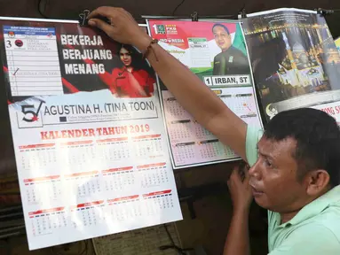 Pekerja menunjukkan kalender tahun 2019 di kawasan Senen, Jakarta, Jumat (7/12). Menjelang berakhirnya tahun 2018, produksi kalender di kawasan pusat percetakan tersebut meningkat 40 persen. (Liputan6.com/Immanuel Antonius)