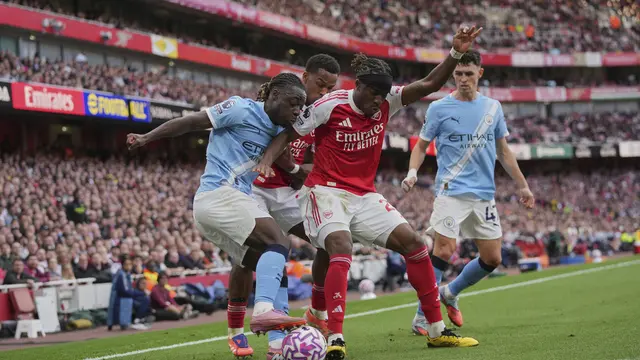 Noni Madueke (kedua dari kanan) berebut bola dengan Jeremy Doku di laga Arsenal vs Manchester City di Emirates Stadium, Minggu (21/09/2025). (AP Photo/Kin Cheung)