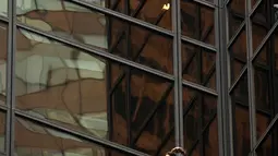 Sejumlah petugas NYPD menunggu seorang pria yang memanjat gedung Trump Tower sebelum bersiap-siap menahannya di New York, AS, Rabu (10/8). Petugas berhasil menangkap si pria berambut gondrong itu ketika mencapai lantai 21. (REUTERS/Lucas Jackson)