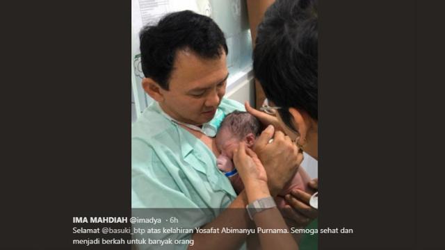 Basuki Tjahaja Purnama atau Ahok menggendong bayinya.