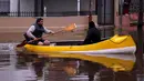 Warga menggunakan Perahu melihat kondisi rumah mereka di daerah Lujan, Argentina, Rabu (12/8/2015). Lebih dari 20.000 orang telah dievakuasi setelah hujan lebat di akhir pekan lalu yang menyebabkan sungai naik dan banjir. (REUTERS/Marcos Brindicci)