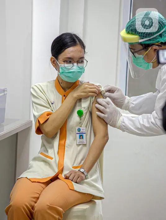 Tenaga kesehatan menjalani vaksinasi virus corona COVID-19 di RSCM, Jakarta, Kamis (14/1/2021). Vaksinasi COVID-19 tahap awal akan menargetkan 1,48 juta tenaga kesehatan. (Liputan6.com/Faizal Fanani)