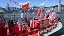Sebuah kapal nelayan dengan spanduk dan bendera untuk menandai peringatan 25 tahun penyerahan Hong Kong dari Inggris ke China berlayar melalui pelabuhan Victoria Hong Kong (28/6/2022). (AFP/Peter Parks)