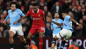 Gelandang Liverpool asal Belanda Ryan Gravenberch berebut bola dengan gelandang Manchester City asal Inggris Grealish (kiri) dan gelandang Manchester City asal Brasil Savinho (kanan) selama pertandingan sepak bola Liga Primer Inggris antara Liverpool dan Manchester City di Anfield, Liverpool, Inggris barat laut pada 1 Desember 2024.Adrian Dennis / AFP