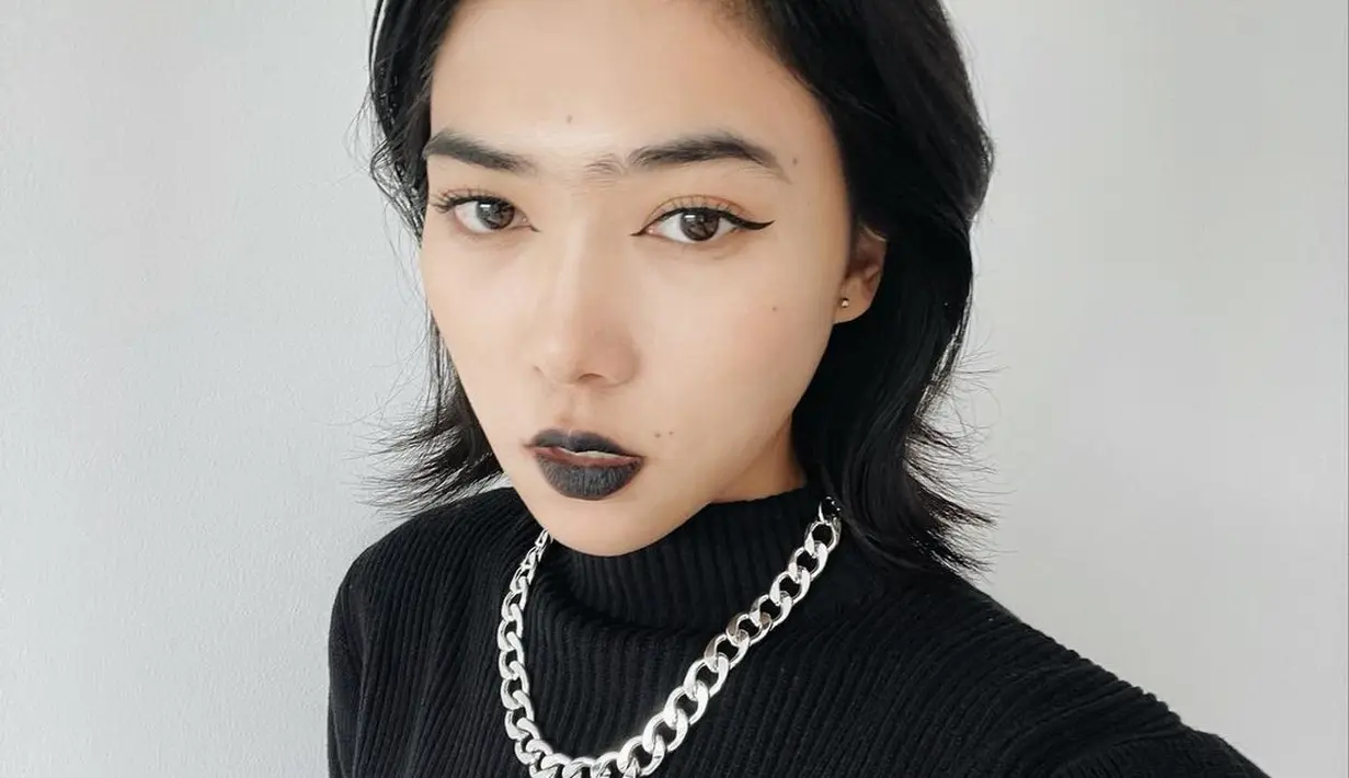 Lipstik dan aksesori mampu membuat outfit sweater knit semakin edgy dengan perona bibir warna gelap dan kalung rantai silver (Foto: Instagram @isyanasarasvati)
