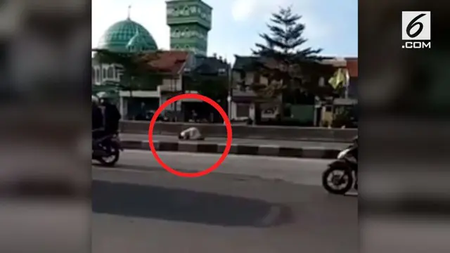 Seorang pria menunaikan salat ditengah jalan raya depan Masjid.