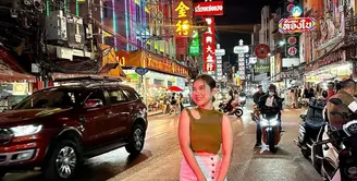Berpose di China Town, pelantun ‘Terlukis Indah’ itu tampil keren dengan padanan cut out top warna hijau cerah, pencil skirt, sneakers, dan shoulder bag.  [Foto: IG/zivamagnolya].