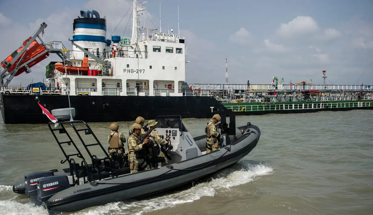 Anggota TNI AL mengawal kapal berbendera Singapura ke pelabuhan Surabaya, Jawa Timur, 10/5). Sembilan tersangka diduga melakukan pembajakan terhadap kapal tanker berbendera Singapura di perairan Tanjung Puting, Kalimantan. (AFP PHOTO/JUNI KRISWANTO)
