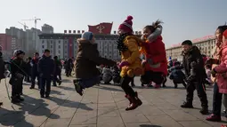 Sejumlah anak bermain lompat tali saat merayakan hari libur Tahun Baru Imlek di alun-alun Kim Il Sung di Pyongyang, Korea Utara (16/2). Dalam perayaan Imlek di Korea Utara ini tidak terlihat ornamen dan aksesoris khas Tionghoa. (AFP Photo/Kim Won-Jin)