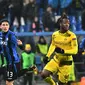 Bek Atalanta, Mattia Caldara dan pemain Borussia Dortmund, Michy Batshuayi berebut bola pada leg kedua babak 32 besar Liga Europa di MAPEI Stadium Citta del Tricolore , Jumat (23/2). Dortmund lolos ke babak 16 besar usai imbang 1-1. (Vincenzo PINTO/AFP)