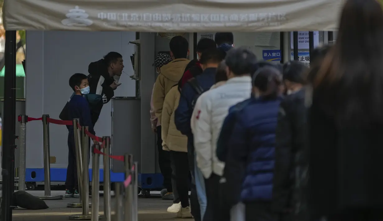 Orang-orang mengantre untuk tes COVID-19 rutin mereka di tempat pengujian virus corona di kawasan pusat bisnis di Beijing, Rabu (16/11/2022). Secara nasional, China melaporkan sekitar 20.000 kasus, naik dari sekitar 8.000 minggu lalu.  (AP Photo/Andy Wong)