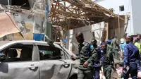 Petugas polisi mengecek sebuah mobil di lokasi serangan bom mobil di Distrik Hamarwayne, Mogadishu, Ibu Kota Somalia (4/2). Setidaknya sembilan orang tewas dan beberapa lainnya cedera akibat serangan bom mobil tersebut. (AFP Photo/Abdirazak Hussein Farah)
