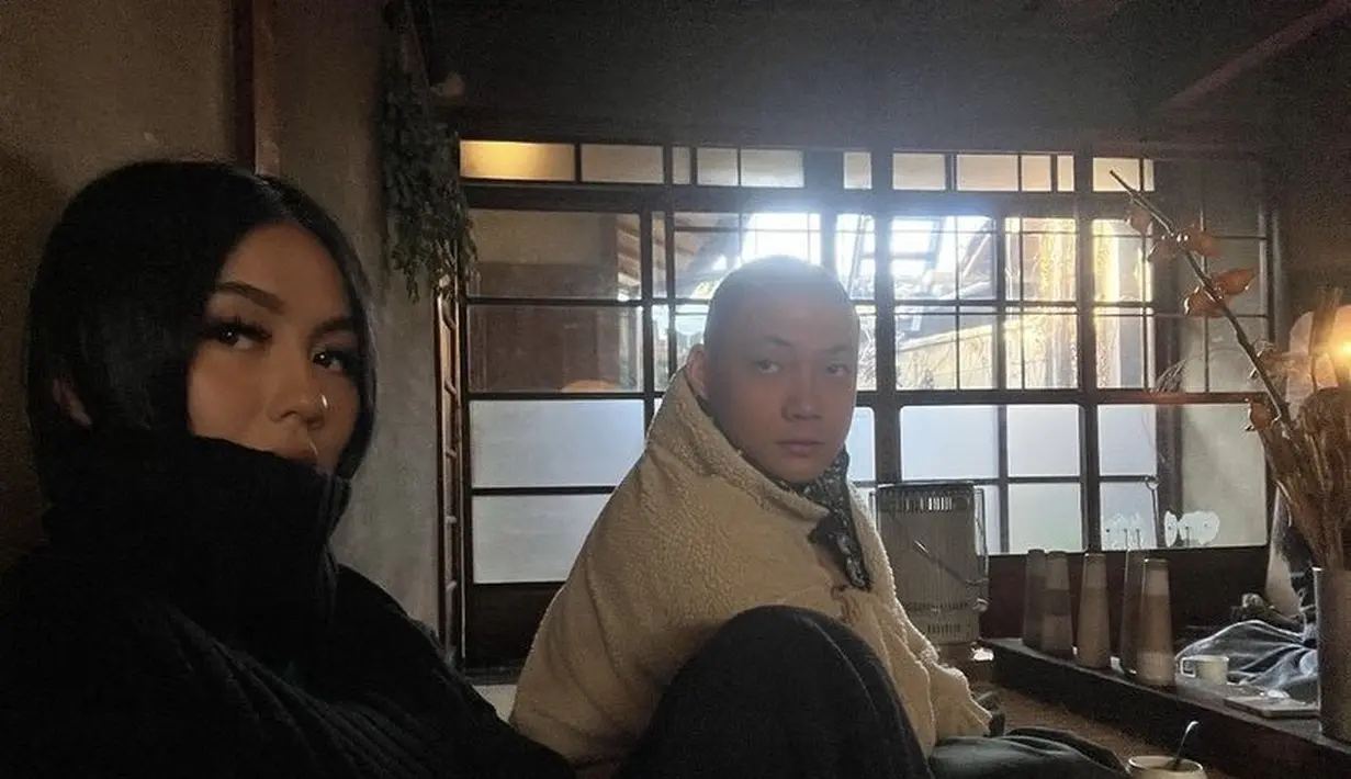 Agnez tampil dengan knitwear turtleneck hitam, sedangkan Adam mengenakan jaket berbulu warna putih.  [@agnezmo]