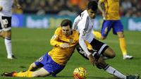 Pemain Barcelona, Lionel Messi, terjatuh saat berebut bola dengan pemain Valencia, Danilo Barbosa, pada laga La Liga Spanyol di Stadion Mestalla, Spanyol, Sabtu (5/12/2015). (AFP Photo/Jose Jordan)