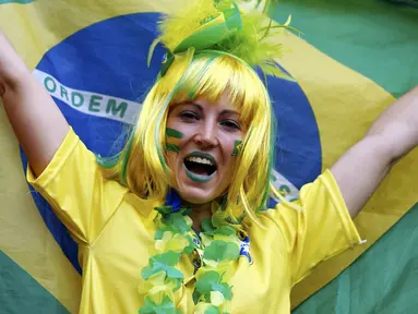 Gaya salah satu suporter wanita Brasil saat menyaksikan langsung Daniel Alves dkk berlaga melawan Kamerun di Stadion Nasional Brasil, (23/6/2014). (REUTERS/Dominic Ebenbichler)