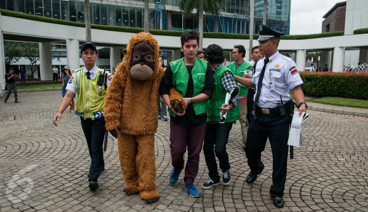 Petugas keamanan menghalau aktivis Greenpeace Indonesia, pewakilan Tim Cegah Api, dan Orangutan melakukan teatrikal saat aksi damai di kawasan kantor HSBC, kompleks World Trade Center (WTC) I, Jakarta, Kamis (9/2). (Liputan6.com/Gempur M Surya)