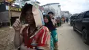 Banyak warga memilih untuk tidur di beberapa titik di pinggir jalan karena faktor rumah hancur sembari menunggu bantuan tiba. Tampak dalam foto, para penyintas mengantre untuk menerima bantuan di daerah yang terdampak banjir bandang di Aceh Tamiang, Sumatra, Jumat 5 Desember 2025. (AP Photo/Binsar Bakkara)