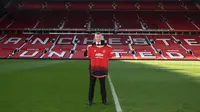 Ole Gunnar Solskjaer menunjukkan jersey Manchester United saat konferensi pers di Stadion Old Trafford, Inggris, (28/3). Manchester United resmi mengumumkan Solskjaer sebagai pelatih permanen mereka untuk beberapa tahun ke depan. (AFP Photo/Oli Scarff)