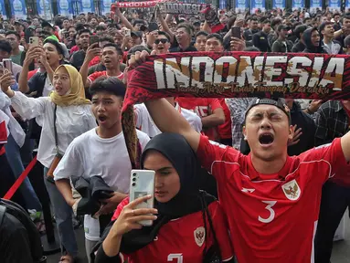 Pendukung Skuad Garuda membentangkan syal jelang nonton bareng pertandingan putaran ketiga Kualifikasi Piala Dunia 2026 zona Asia antara Timnas Indonesia melawan Australia melalui layar videotron di area lingkar luar Stadion Utama Gelora Bung Karno, Jakarta, Kamis (20/3/2025). (Liputan6.com/Angga Yuniar)