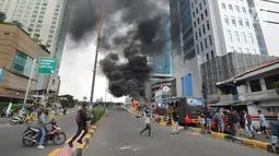 Sejumlah warga mendekati bus polisi yang terbakar di dekat Flyover Slipi, Palmerah, Jakarta Barat, Rabu (22/5/2019). Belum diketahui penyebab terbakarnya dua bus yang terparkir bersama bus polisi lainnya dilokasi tersebut. (merdeka.com/Arie Basuki)