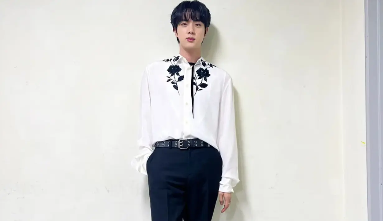 Tampil dengan kemeja putih yang dipadukan celana hitam, penampilan Jin BTS ini terlihat begitu menawan. Terlebih lagi, ornamen bunga pada bagian bahu membuat penampilan pria 29 tahun ini semakin terlihat memesona. (Liputan6.com/IG/@jin)