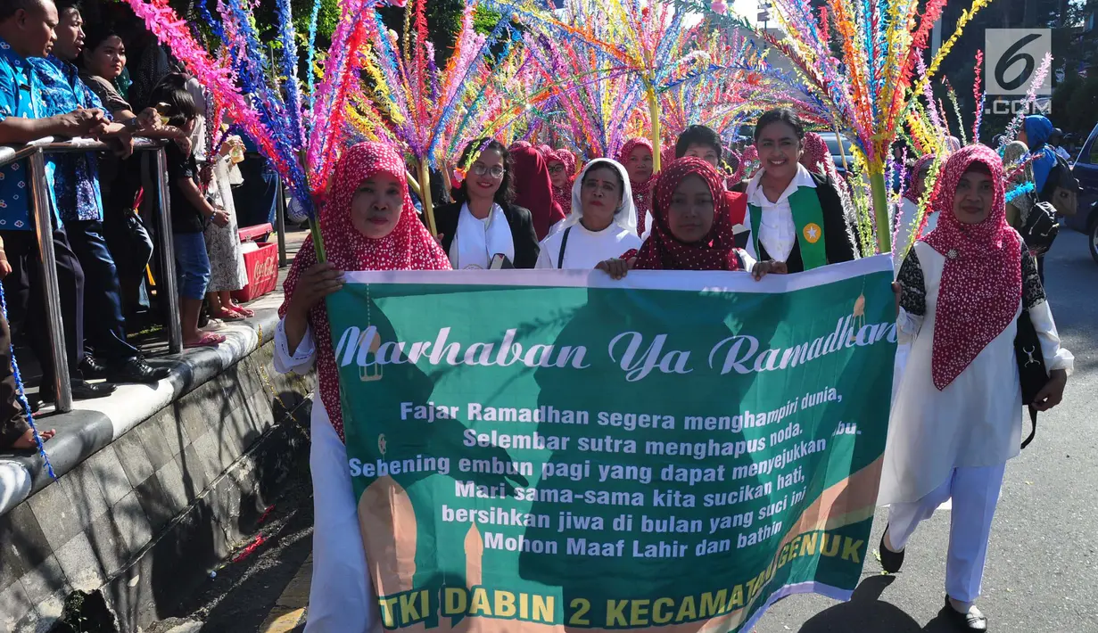 Sejumlah warga membawa poster saat mengikuti Karnaval Budaya Dugderan untuk menyambut datangnya bulan Ramadan di Lapangan Simpang Lima Semarang, Jumat (3/5/2019). Karnaval yang melibatkan kurang lebih 2.500 peserta tersebut digelar tanggal 3 Mei dan 4 Mei. (Liputan6.com/Gholib)