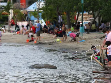 Pengunjung bersama anak-anak menikmati suasana Pantai Indah Taman Impian Jaya Ancol, Jakarta, Kamis (29/10/2020). Libur panjang di masa pemberlakuan PSBB transisi Jakarta dimanfaatkan warga untuk mengunjungi lokasi-lokasi wiisata. (Liputan6.com/Helmi Fithriansyah)