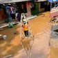 Petugas PLN bersiap memeriksa jaringan listrik yang sudah diputus agar tidak membahayakan, Bango, Pondok Labu, Jakarta, Sabtu (20/2/2021). Banjir di Jakarta berdampak pada 180 unit Gardu Distribusi dan 61.320 pelanggan sehingga terjadi pemadaman di sejumlah wilayah. (merdeka.com/Arie Basuki)
