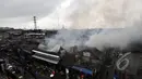 Asap membumbung usai petugas Damkar menjinakkan api yang membakar sejumlah rumah di kawasan Pasar Kembangan, Senen, Jakarta, Senin (19/1/2015).  (Liputan6.com/Miftahul Hayat)