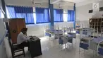Seorang guru beraktivitas di ruang kelas yang kosong di Mts Annajah, Petukangan, Jakarta Selatan, Senin (5/8/2019). Masih padamnya listrik di sejumlah kawasan Jakarta membuat kegiatan belajar mengajar terganggu hingga memaksa pihak sekolah memulangkan siswa lebih awal. (merdeka.com/Arie Basuki)