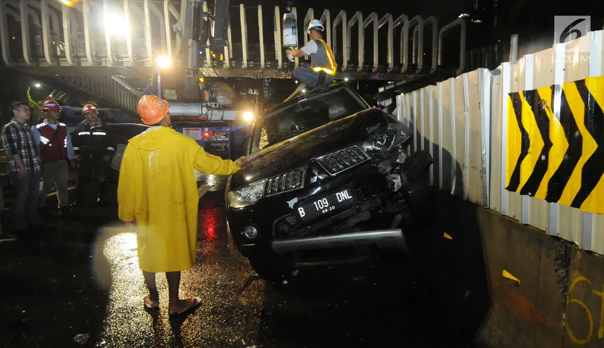 Petugas mengevakuasi mobil pajero yang menabrak pagar pembatas pembangunan proyek  stasiun Mass Rapid Transit (MRT) di belakang Polda Metro Jaya, Jakarta, Jumat (25/1). Tidak ada korban jiwa dalam kecelakaan tunggal tersebut. (Merdeka.com/Dwi Narwoko)