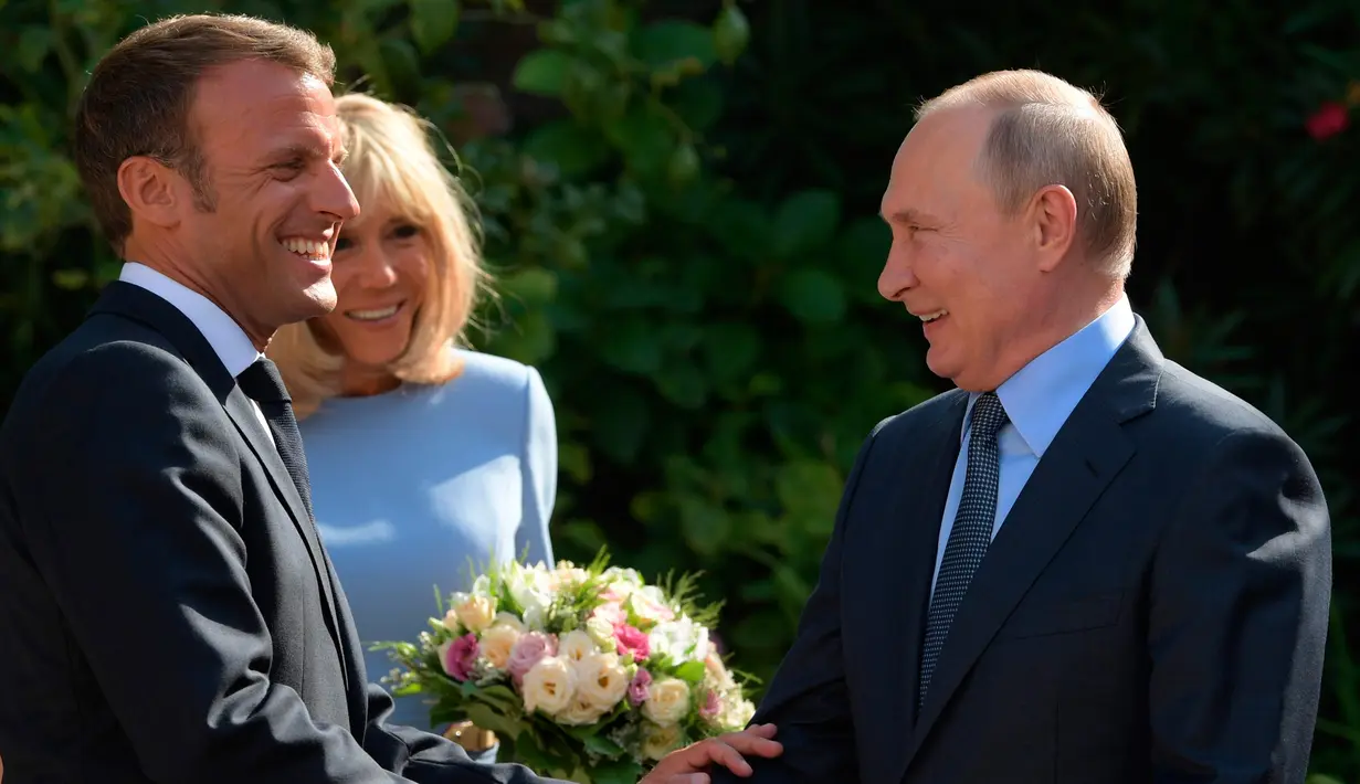 Presiden Prancis Emmanuel Macron (kiri) dan istrinya Brigitte menyambut Presiden Rusia Vladimir Putin di Benteng Bregancon, Bormes-les-Mimosas, Prancis, Senin (19/8/2019). Macron dan Putin membahas di antaranya krisis Ukraina, Iran, dan Suriah. (Alexei Druzhinin, Sputnik, Kremlin Pool Photo via AP)