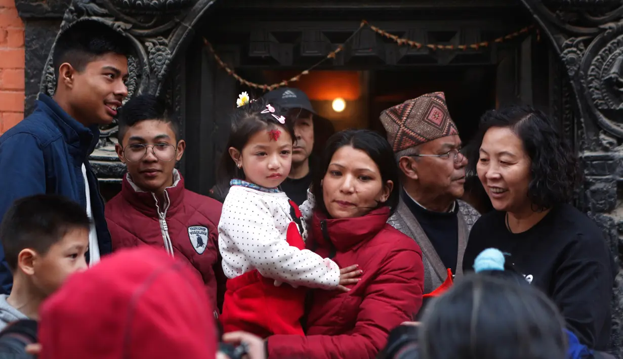 Nihira Bajracharya digendong ibunya saat tiba untuk pemilihan Dewi Hidup atau Kumari di sebuah kuil Hindu di Patan, Lalitpur, Nepal (5/2). Selama menjadi Kumari, Nihira akan dirawat oleh pengasuh yang ditunjuk secara khusus. (AP Photo / Niranjan Shrestha)
